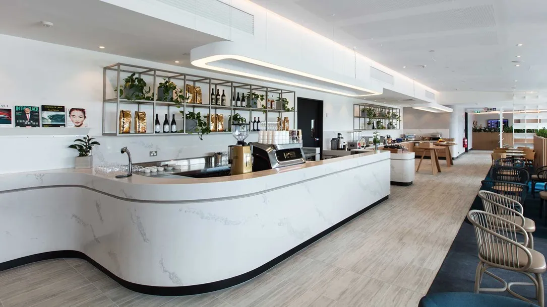 Modern café interior with a curved Caesarstone thermoformed countertop and minimalist design.